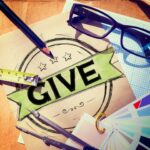 Creative desk with "GIVE" badge and tools