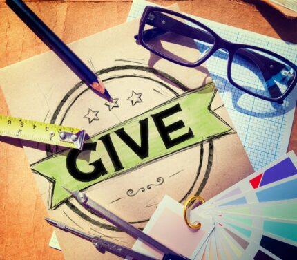 Creative desk with "GIVE" badge and tools