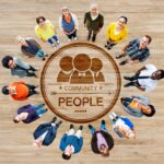 People standing in circle around community emblem