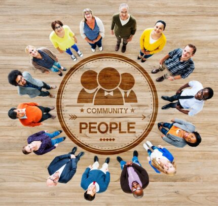 People standing in circle around community emblem